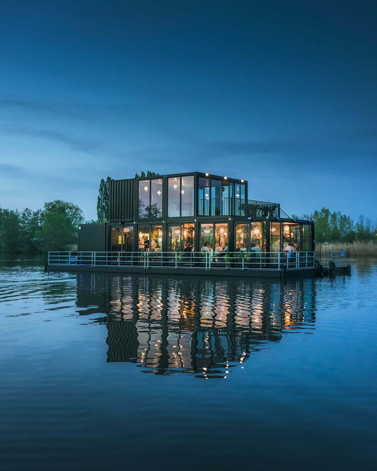 The Dinner on the Lake floating restaurant glowing at dusk in the middle of the lake